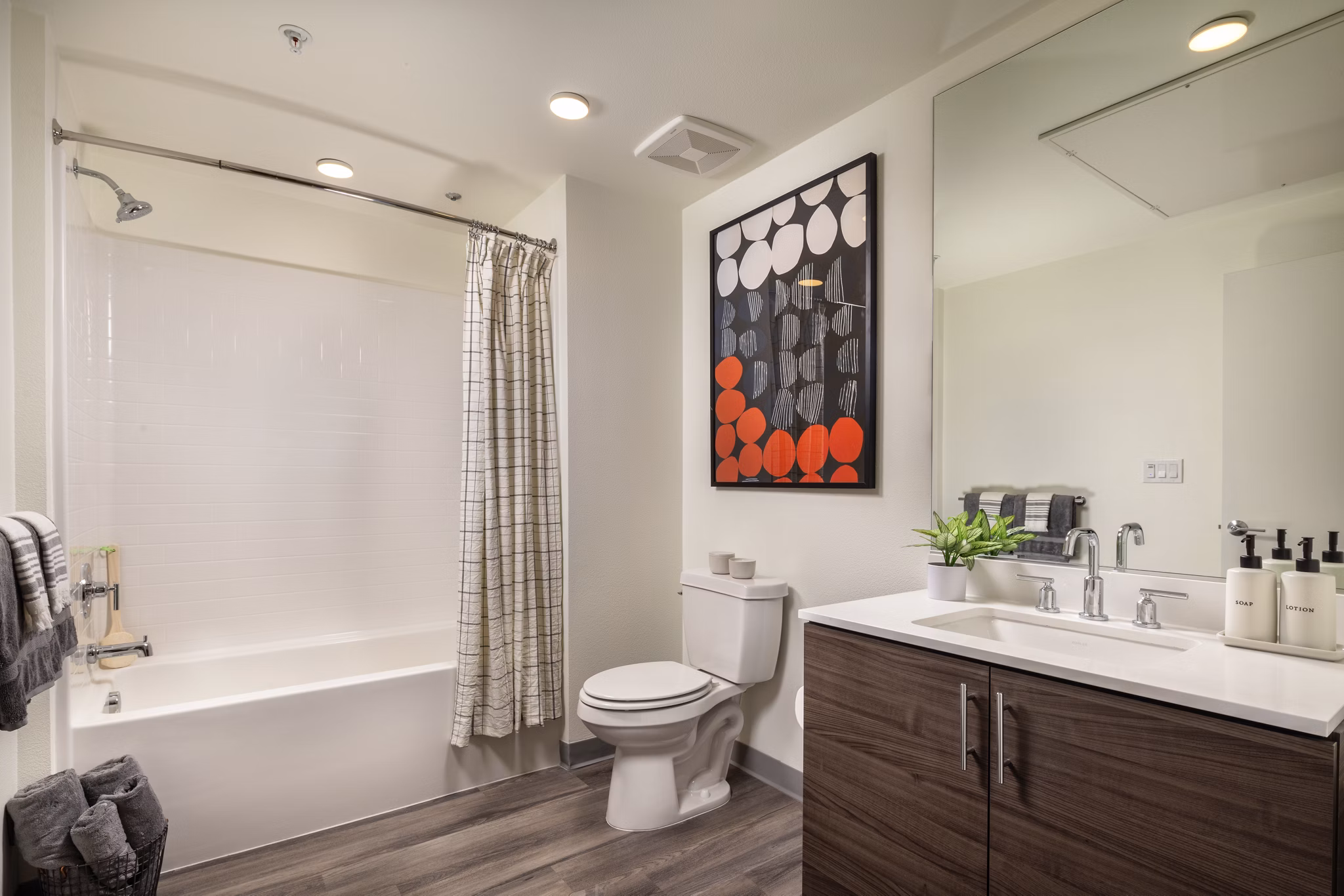 Luxurious bathroom featuring sleek fixtures and large mirrors at Rise Hollywood Apartments