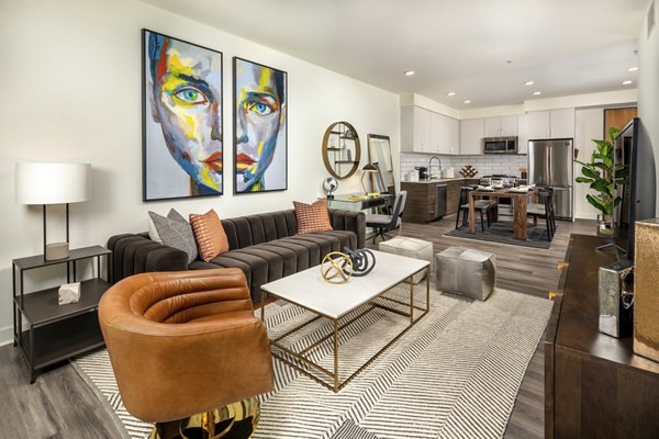 Modern living room with sleek furnishings and large windows at Rise Hollywood Apartments