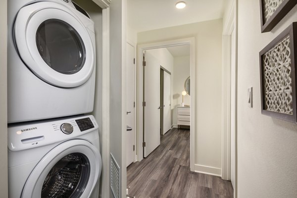 Modern laundry room with high-efficiency washers and dryers at Rise Hollywood Apartments