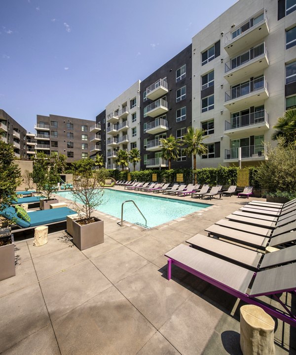 Swimming pool with lounge chairs at Rise Hollywood Apartments in luxury setting, perfect for relaxation and entertaining