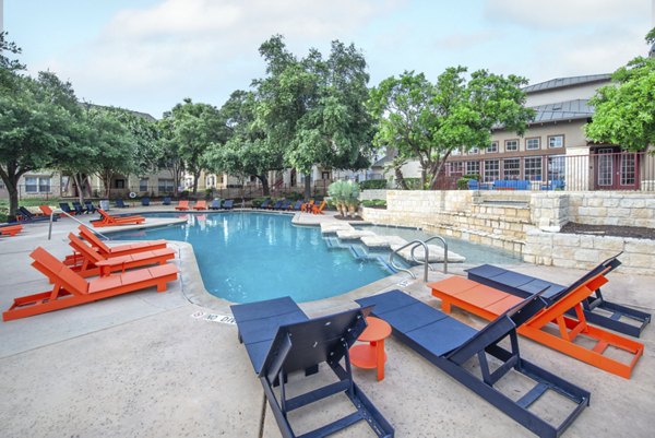 Resort-style pool at Hillside Ranch Apartments with lounge chairs and landscaped surroundings