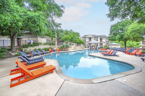 Sparkling outdoor pool with lounge chairs at Hillside Ranch Apartments, perfect for relaxation and leisure activities