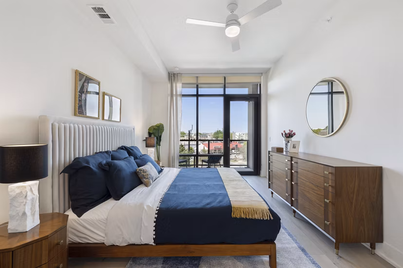 Bedroom featuring elegant decor and large windows at The Westcott Apartments