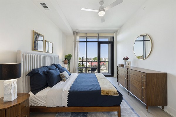Bedroom featuring elegant decor and large windows at The Westcott Apartments