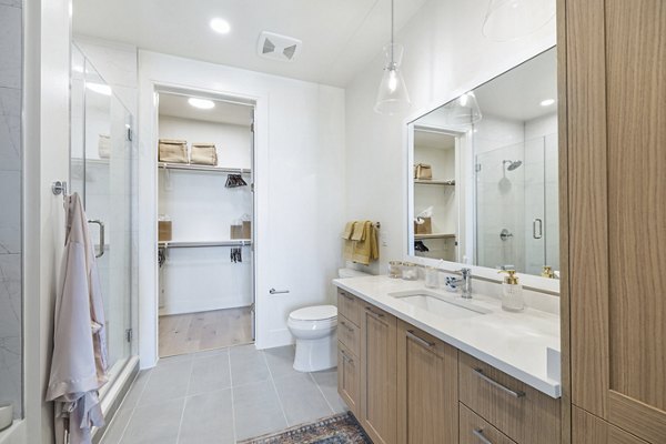 Bathroom featuring marble countertops and modern fixtures in The Westcott Apartments