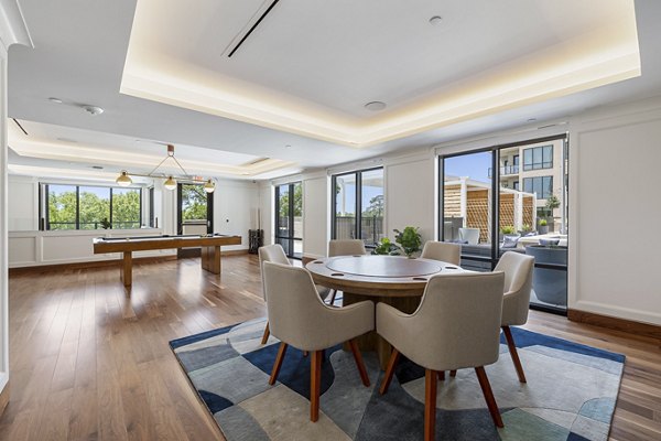 Bright modern dining area with a pool table and large windows in luxury apartments