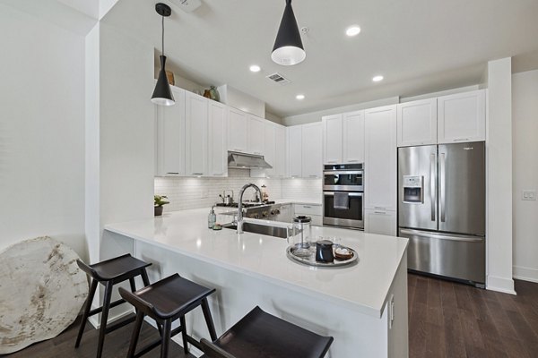 Modern kitchen with stainless steel appliances in The Westcott Apartments, luxury living space