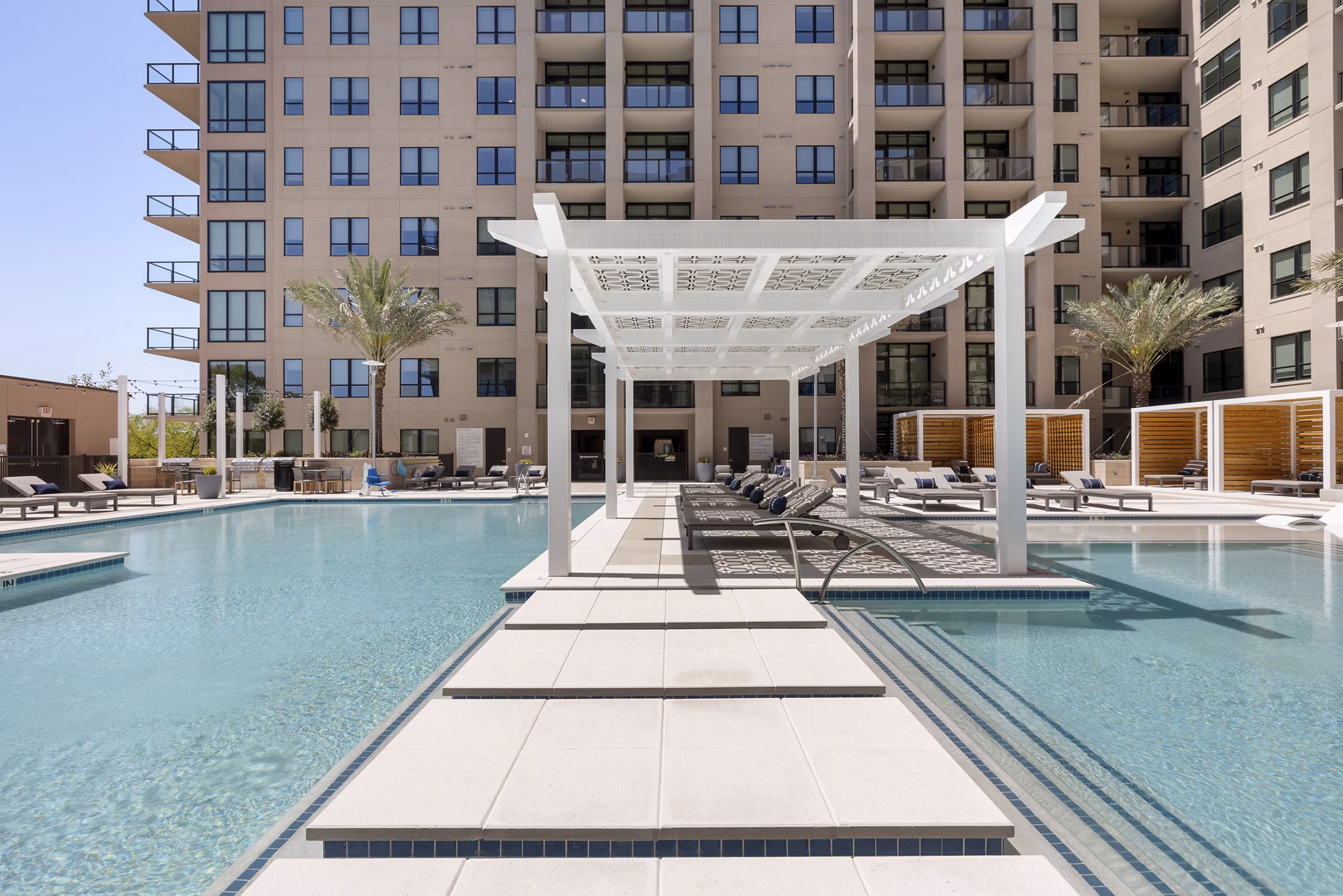 Resort-style pool with lounging areas at The Westcott Apartments, luxury living in a vibrant community setting