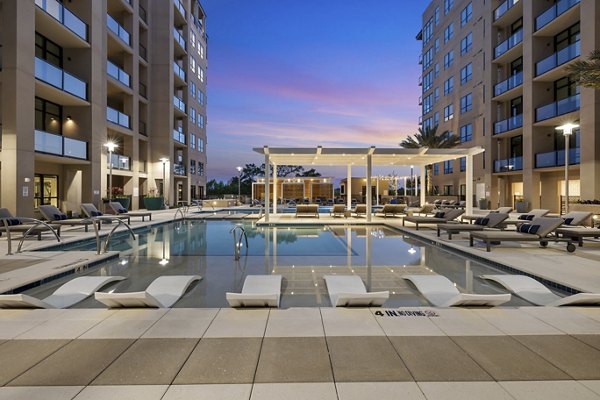 Infinity pool with sun loungers at The Westcott Apartments, offering luxury amenities and serene surroundings
