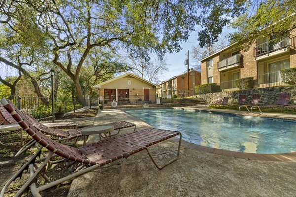 Luxury swimming pool with lounge seating at Treehouse Apartments, ideal for relaxation and socializing in an upscale living community