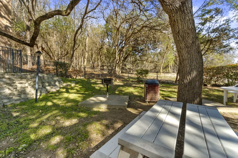 Outdoor grill area surrounded by lush landscaping at Treehouse Apartments, ideal for social gatherings and alfresco dining