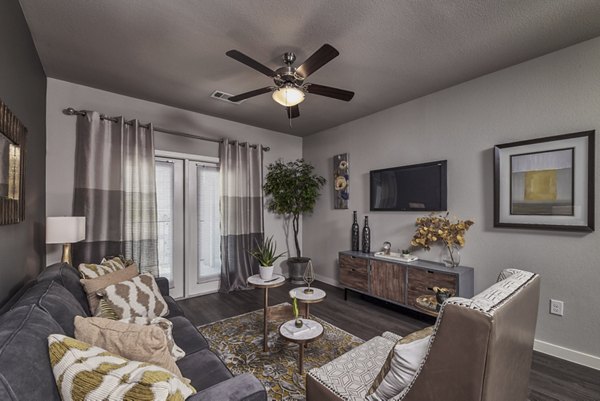 Modern living room with chic furnishings and large windows in Roots at Waco Apartments