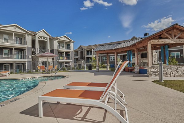 Luxury poolside lounge with sunbeds at Roots at Waco Apartments, a premier destination for relaxation and style