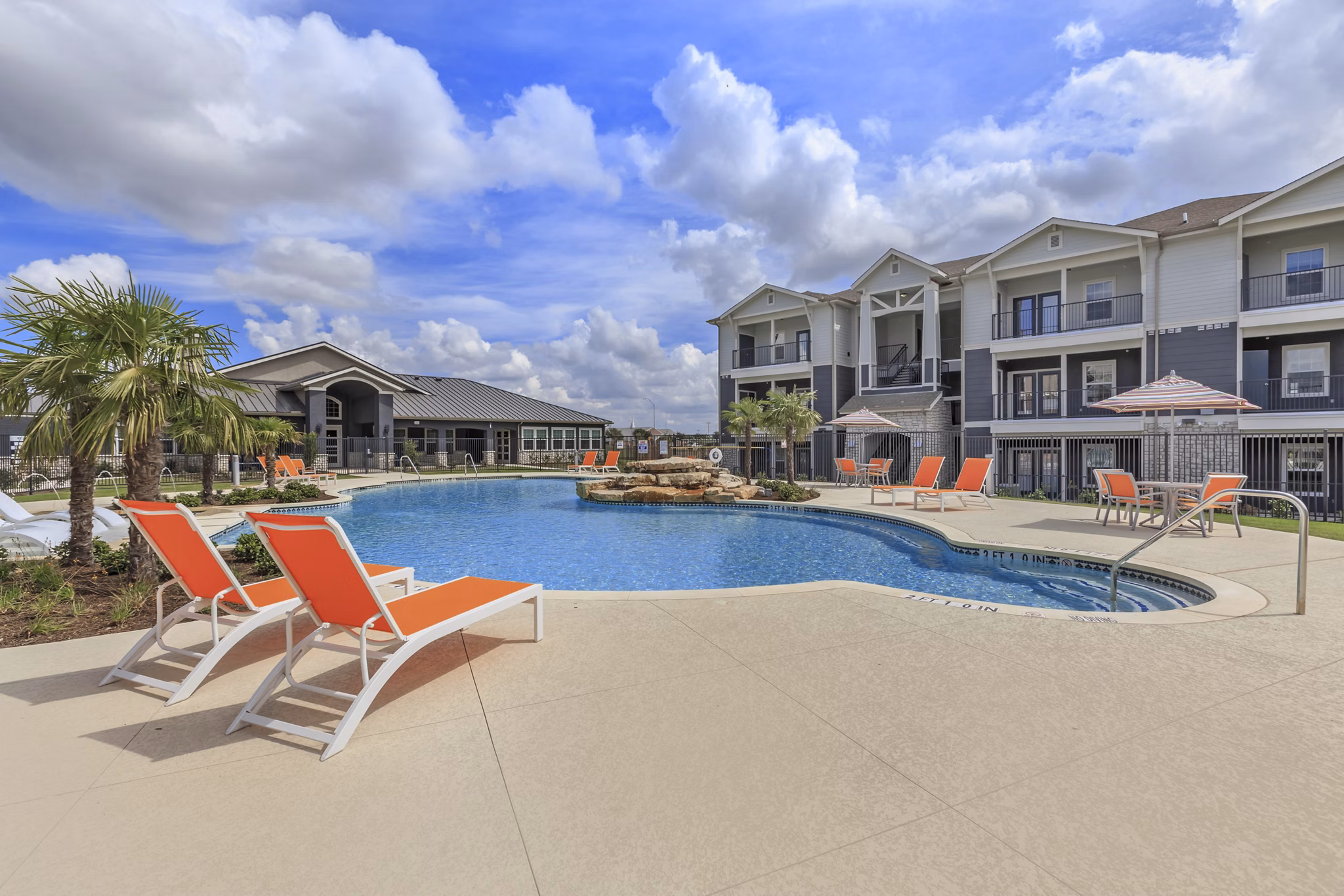 Resort-style pool at Roots at Waco Apartments with lush landscaping, perfect for relaxation and leisure activities