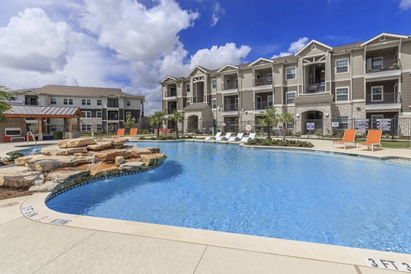 Luxurious outdoor pool area at Roots at Waco Apartments offering a relaxing oasis for residents seeking comfort and style