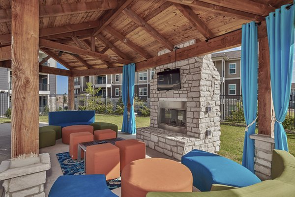 Fire pit at Roots at Waco Apartments: Cozy outdoor sitting area with a fire pit offering luxury relaxation and ambiance
