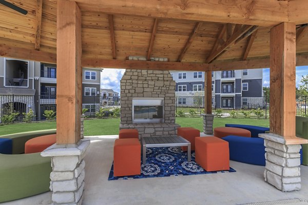 Cozy fire pit area at Roots at Waco Apartments, perfect for outdoor gatherings and relaxation evenings in the luxury setting