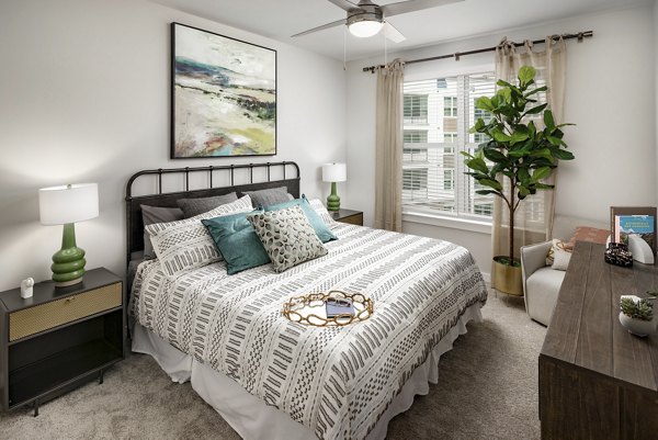 Bedroom featuring elegant decor and large windows at Overture Powers Ferry Apartments