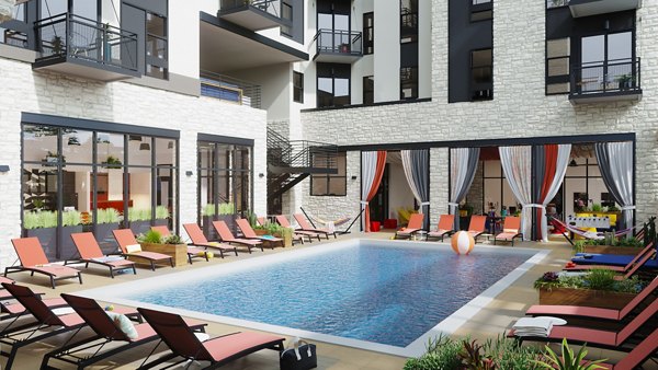 Modern outdoor pool at The Parlor Apartments featuring luxury sun loungers and stylish decking areas