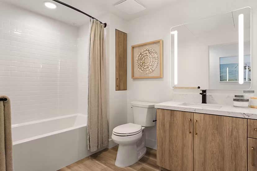 Modern bathroom with sleek fixtures and large mirror at Colony Parc Apartments