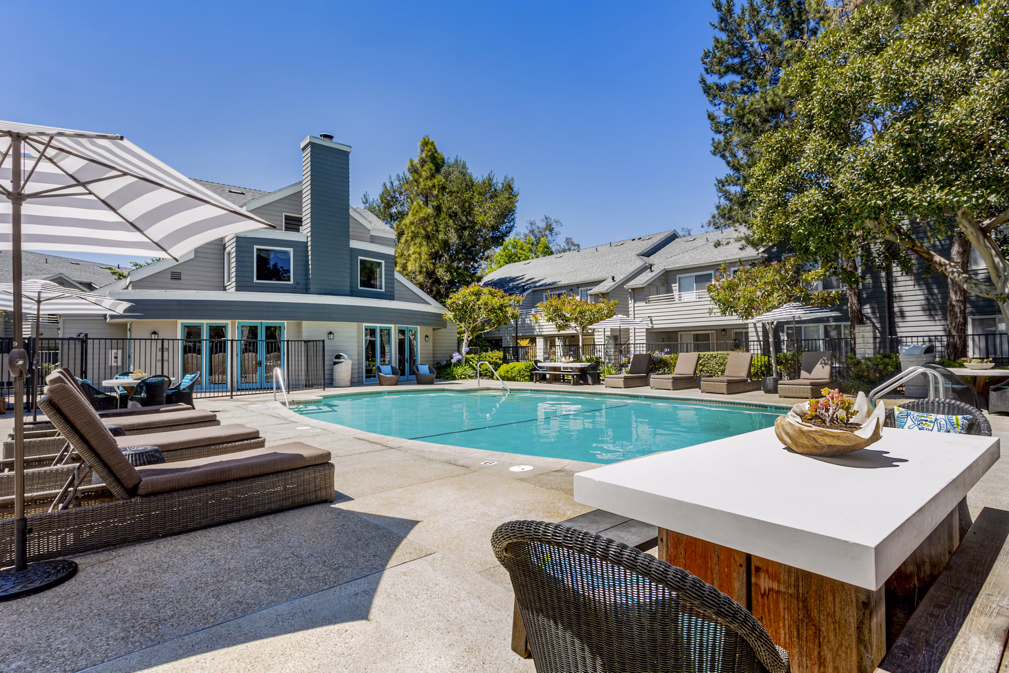Resort-style pool at Colony Parc Apartments with lounge chairs and lush landscaping