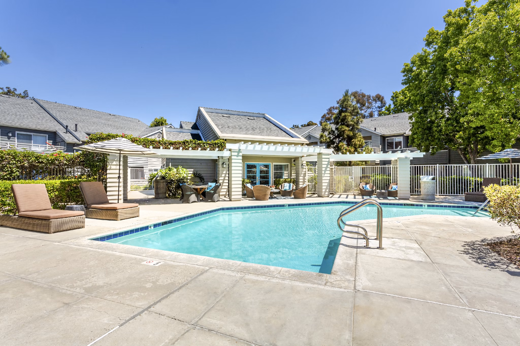 Beautiful outdoor pool with lounger chairs at Colony Parc Apartments, perfect for relaxation and leisure activities in a luxurious setting