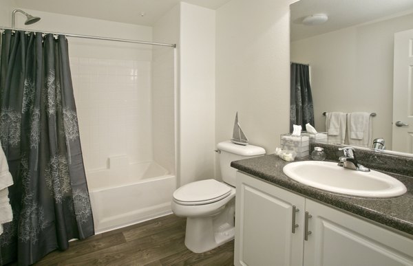 Bathroom with sleek fixtures and marble countertops in Parc Chateaux Apartments