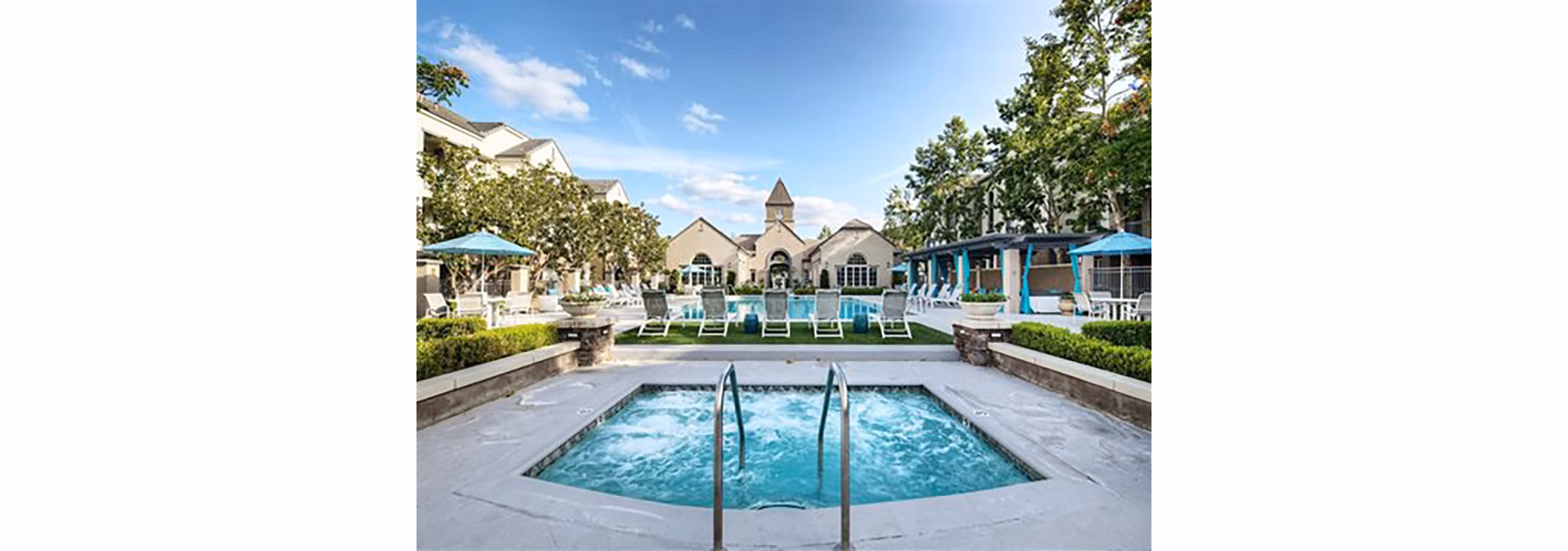 Resort-style pool with lush landscaping at Parc Chateaux Apartments offering luxury amenities for residents