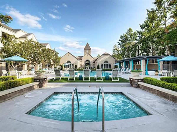 Resort-style pool with lush landscaping at Parc Chateaux Apartments offering luxury amenities for residents