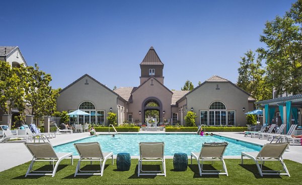 Luxurious pool area at Parc Chateaux Apartments with sun loungers and lush landscaping