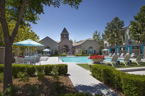 Outdoor pool with resort-style seating at Parc Chateaux Apartments offering a luxury experience
