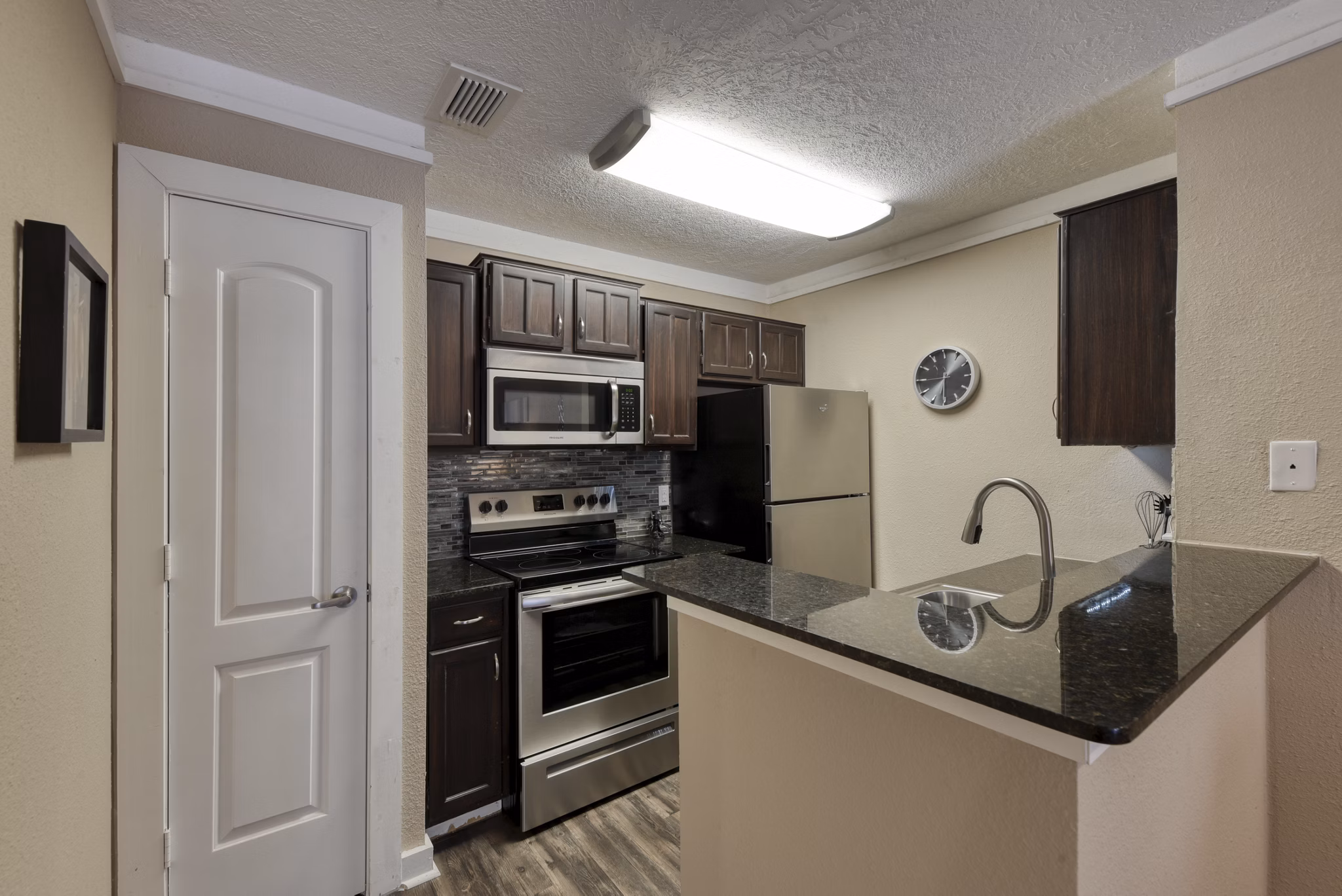 Modern kitchen featuring granite countertops and stainless steel appliances at Stone Chase Apartments