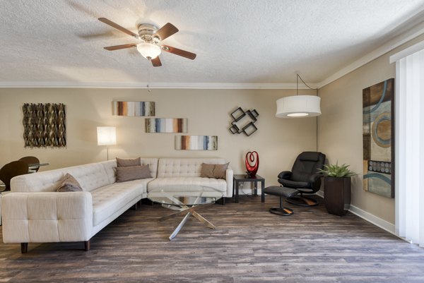 Bright living room with modern decor and large windows at Stone Chase Apartments