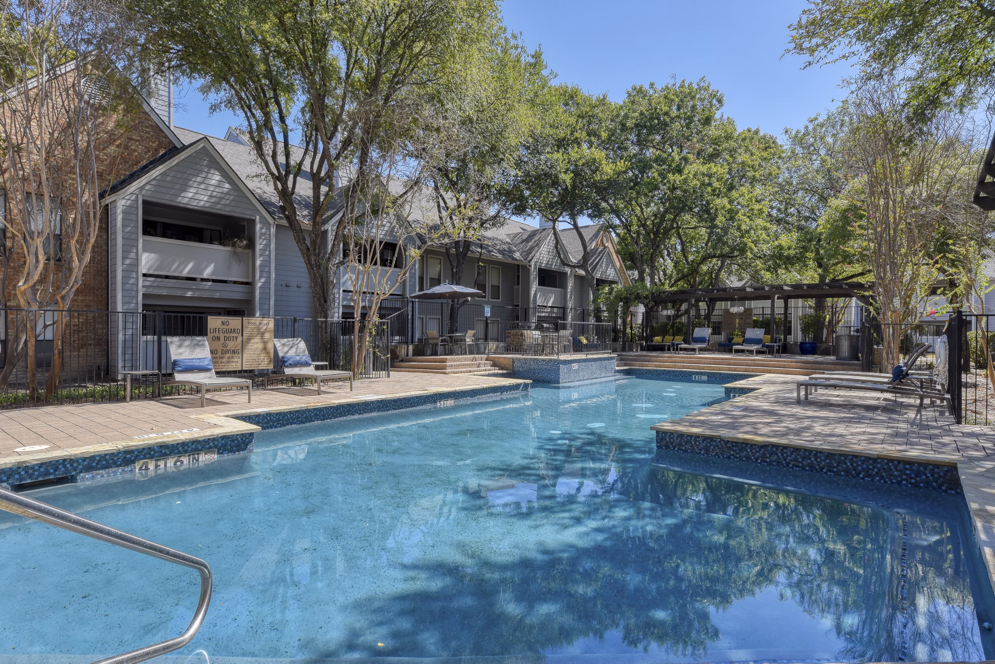 Luxury pool area with lounging chairs at Stone Chase Apartments, perfect for relaxation and socializing