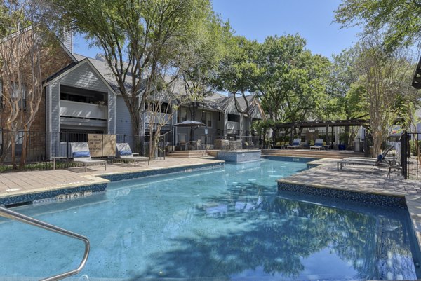 Luxury pool area with lounging chairs at Stone Chase Apartments, perfect for relaxation and socializing
