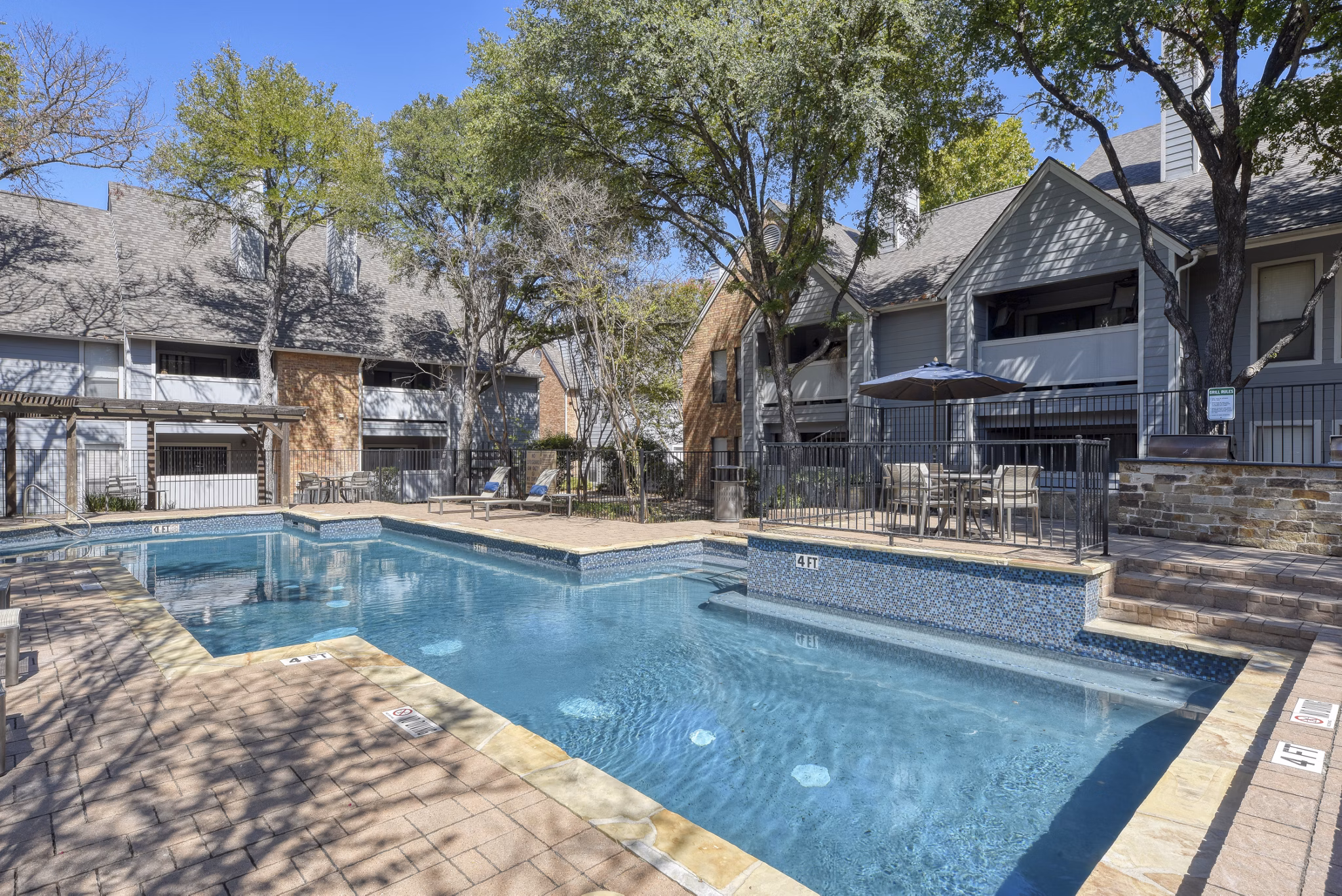 Resort-style pool with lounge chairs at Stone Chase Apartments offering luxury amenities in a tranquil setting