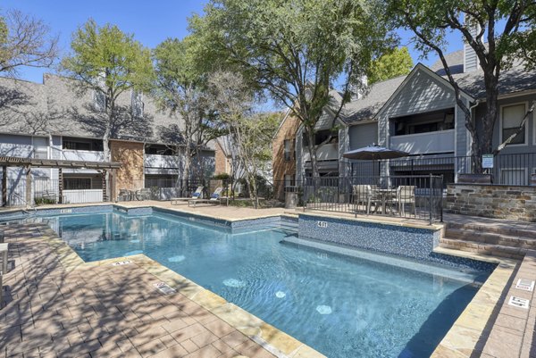 Resort-style pool with lounge chairs at Stone Chase Apartments offering luxury amenities in a tranquil setting