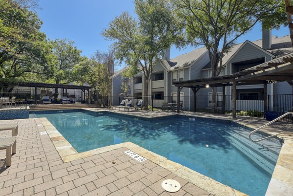 Relaxing outdoor pool at Stone Chase Apartments with lounge chairs and greenery