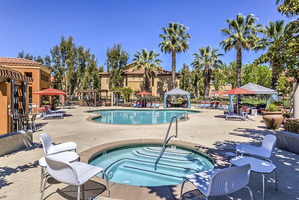 Resort-style pool at Mission Grove Park Apartments with lounge seating and lush landscaping, offering luxury apartment living