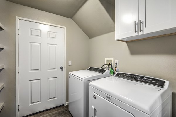 Laundry room equipped with modern washers and dryers at Signature Point Apartments