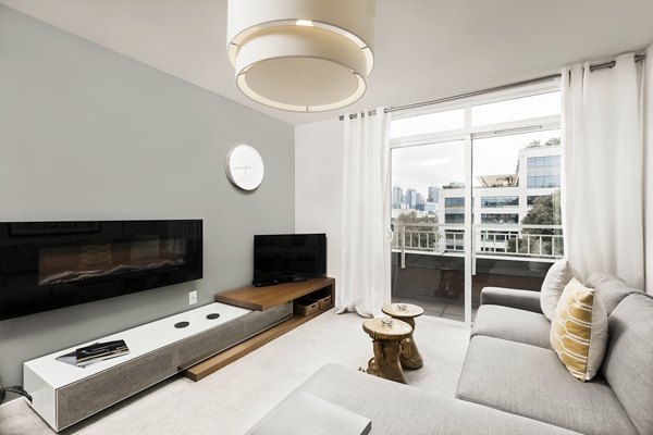 Spacious living room with modern furnishings and large windows at Dexter Lake Union Apartments