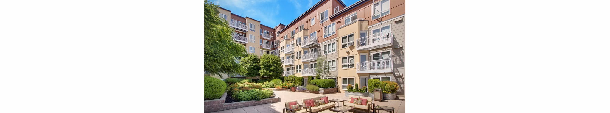 Courtyard featuring landscaped gardens and seating areas at Dexter Lake Union Apartments
