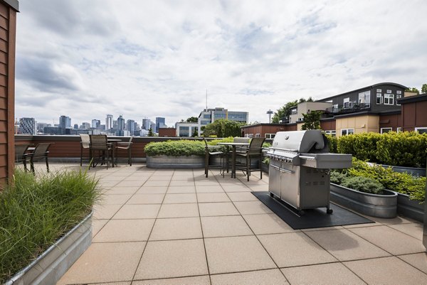 Modern outdoor grill area at Dexter Lake Union Apartments with stainless steel equipment and seating