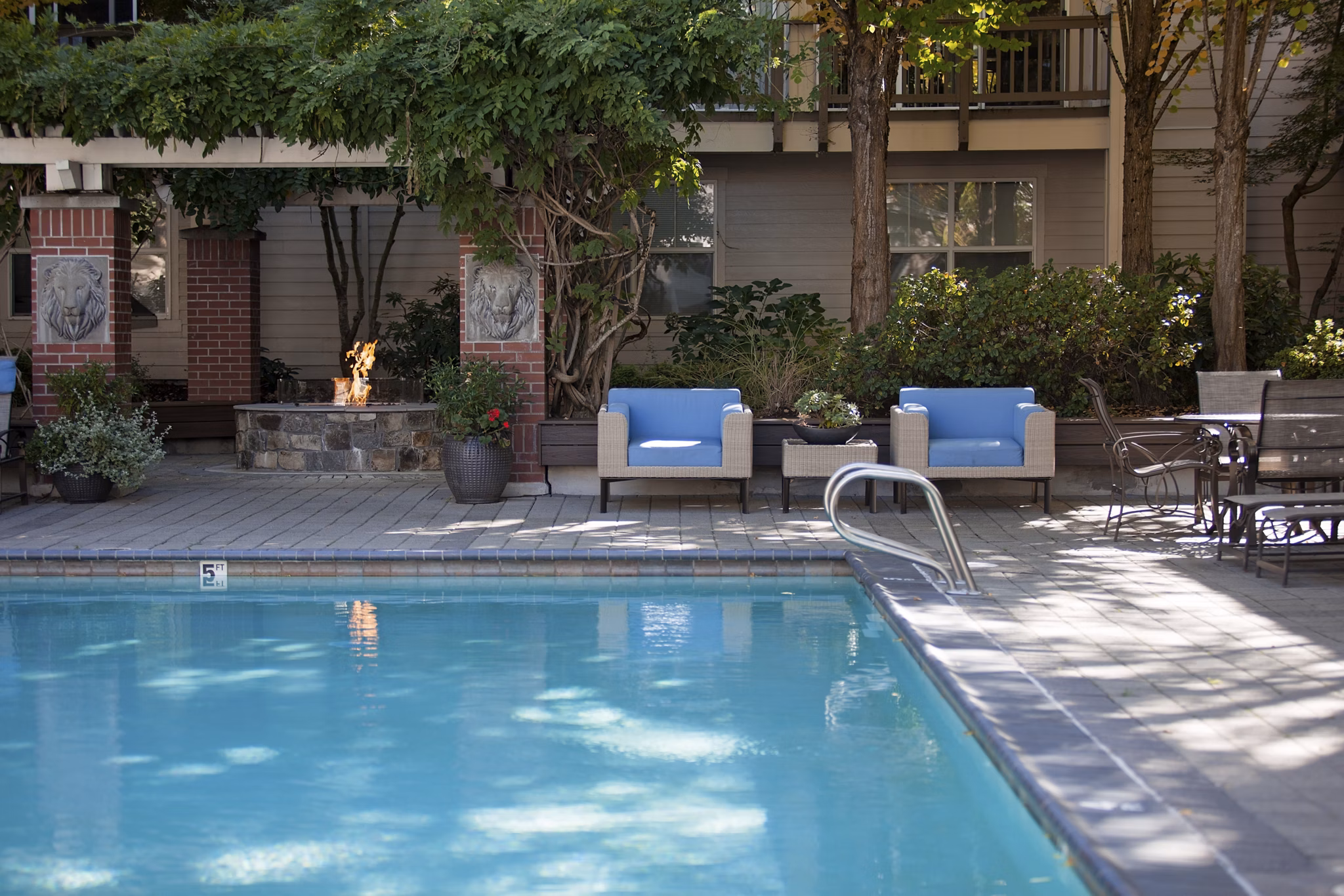 Inviting outdoor pool with lounge seating at Lions Gate South Apartments, perfect for relaxation and socializing in a luxurious setting