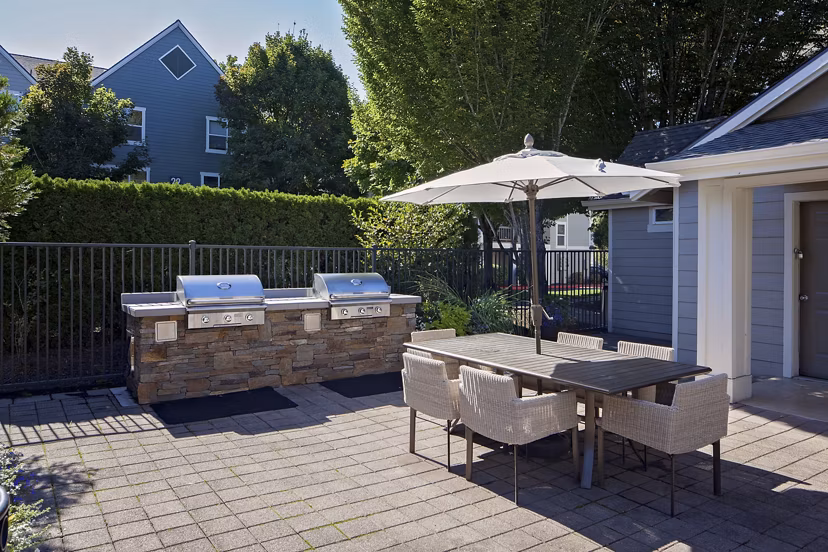 Outdoor grill area with modern seating at Lions Gate South Apartments, ideal for gatherings and leisure in a luxury living environment