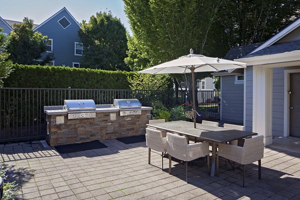 Outdoor grill area with modern seating at Lions Gate South Apartments, ideal for gatherings and leisure in a luxury living environment