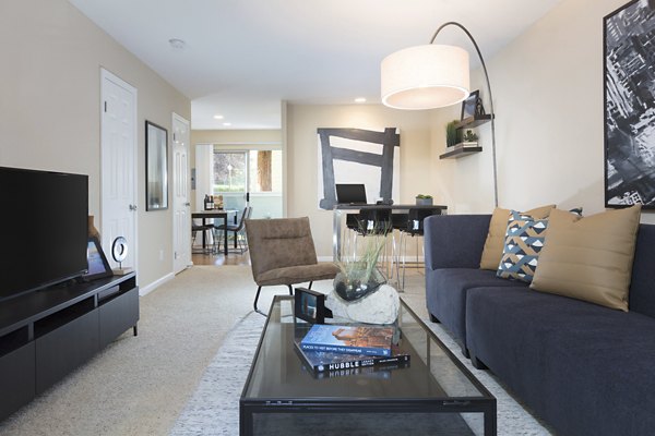 Modern living room featuring stylish furniture and large windows at Central Park at Whisman Station Apartments
