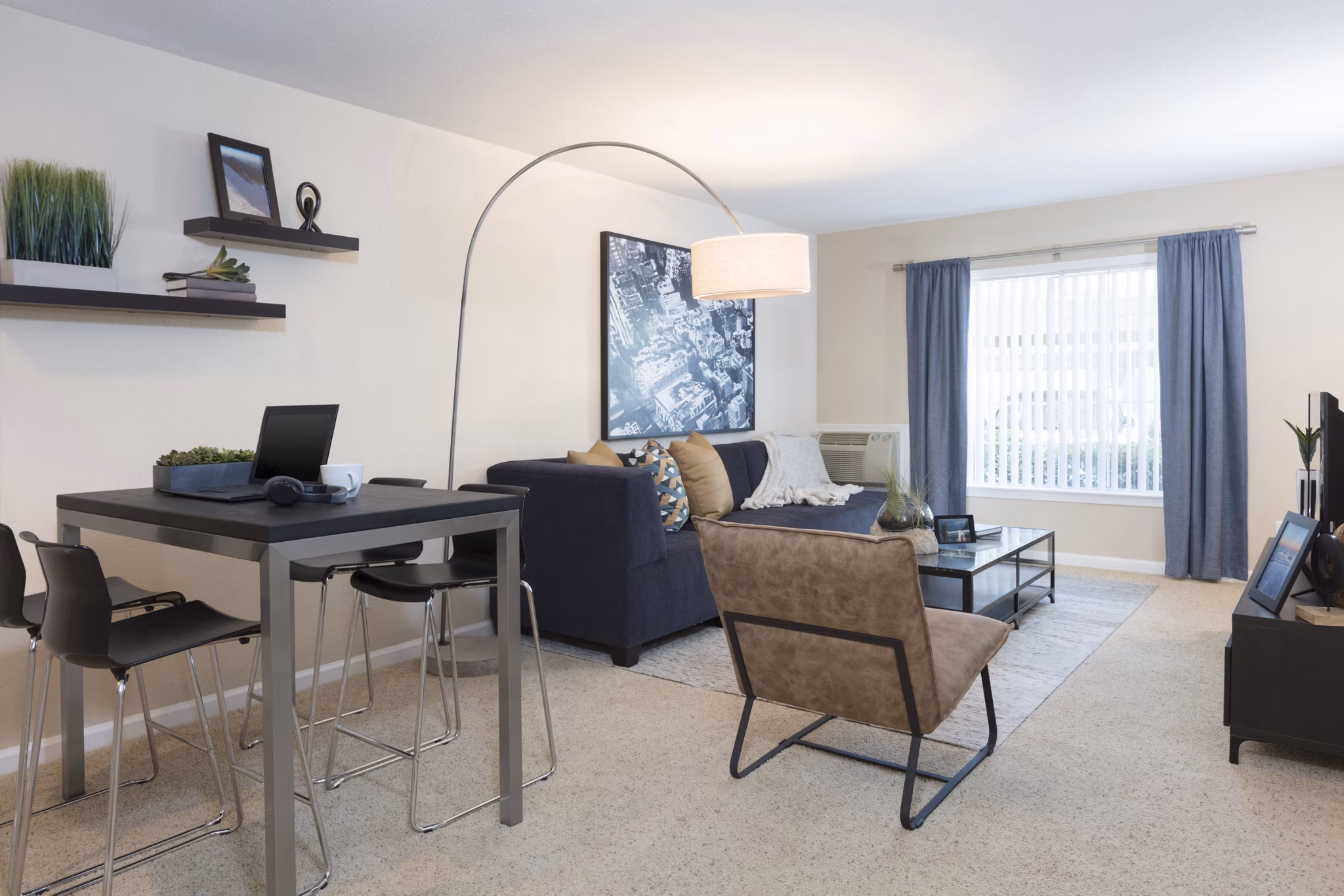 Living room with contemporary decor and large windows at Central Park at Whisman Station Apartments