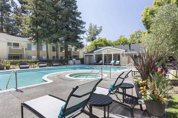 Relaxing pool area with lounge chairs at Central Park at Whisman Station Apartments