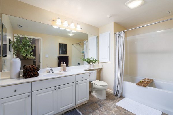 Bathroom featuring sleek fixtures and modern design at Domicilio Apartments